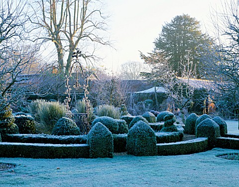 WEST_GREEN_HOUSE_GARDEN__HAMPSHIRE_FROSTED_CLIPPED_BOX_SURROUNDS_AN_OLD_WELL__HEAD_IN_THE_WALLED_GAR