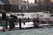 WOODEN LANDING STAGE WITH CONTAINER IN FROST BESIDE THE POOL WITH THE HOUSE IN THE BACKGROUND  JOHN MASSEYS GARDEN  WORCESTERSHIRE