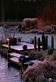 WOODEN LANDING STAGES WITH CONTAINER  STONE BALLS AND ROCKS IN FROST BESIDE THE POOL. JOHN MASSEYS GARDEN  WORCESTERSHIRE