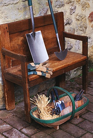 WOODEN_BENCH_BESIDE_WALL_WITH_TRUG__GLOVES_AND_SPADE