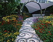 CHELSEA FLOWER SHOW 2004: LIFE GARDEN DESIGNED BY JANE HUDSON AND ERIK DE MAEIJER: PEBBLE MOSAIC PATH BY MAGGY HOWARTH LEADS TO SEAT  TENSILE FABRIC CANOPY AND HOT PLANTING