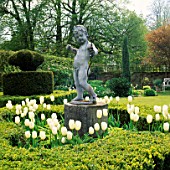 A CUPID SURROUNDED BY SNOW PEAK TULIPS IN THE WHITE GARDEN AT CHENIES MANOR  BUCKINGHAMSHIRE