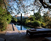 LA CHABAUDE  FRANCE: DESIGNER - PHILIPPE COTTET: THE SWIMMING POOL WITH DECKING  SUNLOUNGERS AND COUNTRYSIDE BEYOND