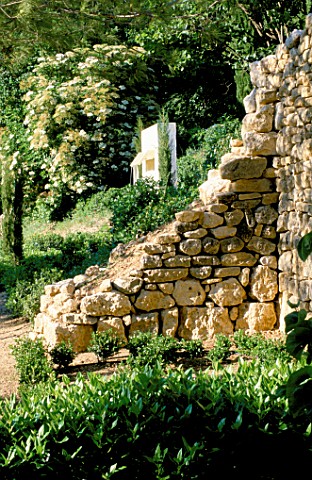LA_CHABAUDE__FRANCE_DESIGNER__PHILIPPE_COTTET_MODERN_WATER_FEATURE_ON_HILLSIDE_WITH_STONE_WALL_IN_FO