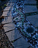 RECYCLED BOTTLES  PEBBLES  GLASS ON CIRCULAR PAVED PATH. DESIGNER: DAVID CHASE