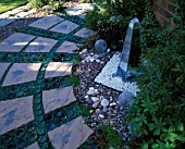 MIRRORED OBELISK WATER FEATURE? SURROUNDED BY RECYCLED GLASS BOTTLES AND CIRCULAR PAVED AREA. DESIGNER: DAVID CHASE