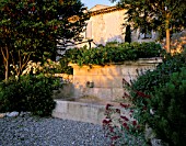 LA CHABAUDE  FRANCE. DESIGNER - PHILIPPE COTTET: STONE WATER FEATURE ON GRAVEL TERRACE WITH CENTRANTHUS RUBER