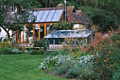 THE CONSERVATORY AND GREENHOUSE SEEN FROM THE LAWN. GREYSTONE COTTAGE  OXFORDSHIRE. DESIGNER: DUNCAN HEATHER