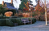 PETTIFERS  OXFORDSHIRE: THE PARTERRE IN WINTER WITH CLIPPED BOX  BETULA ERMANII AND A WOODEN BENCH