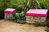 PINK CUSHION TOPPED GABION SEATS IN A GARDEN DESIGNED BY NIC HOWARD AND BARNEY HARRISON. THE GREAT GARDEN CHALLENGE  BLENHEIM PALACE  OXFORDSHIRE