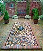 THE PEBBLE POOL GARDEN WITH CLIPPED BOX IN TUBS AND WHITE HEBE. PREEN MANOR GARDEN  SHROPSHIRE