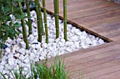 CHUNKS OF LIMESTONE FORM MULCH AROUND BAMBOO STEMS AND DECKING PATHWAY  IN HIS LATE HIGHNESS SHAIKH ZAYED BIN SULTAN AL-NAYHANS GARDEN BY CHRISTOPHER BRADLEY-HOLE. CHELSEA 2005