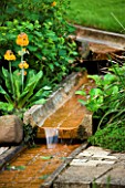 WATER FEATURE: RILL ON DIFFERENT LEVELS WITH PRIMULAS BESIDE. WINGWELL NURSERY   RUTLAND