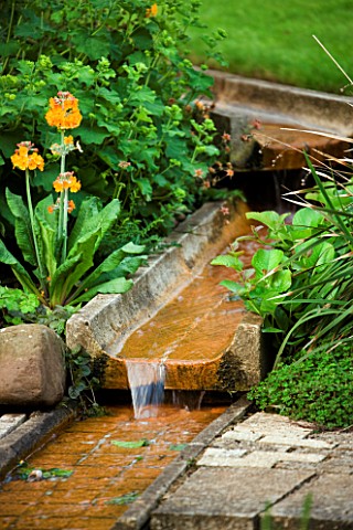 WATER_FEATURE_RILL_ON_DIFFERENT_LEVELS_WITH_PRIMULAS_BESIDE_WINGWELL_NURSERY___RUTLAND