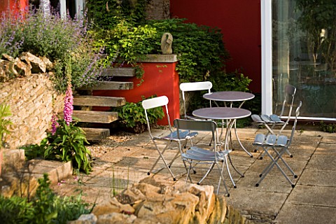METAL_TABLE_AND_CHAIRS_ON_THE_PATIO_WITH_RED_WALL_BEHIND__WINGWELL_NURSERY___RUTLAND