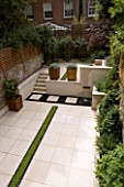 VIEW ACROSS CONTEMPORARY CLASSIC GARDEN WITH PLANTED RILL  COPPER WATER FEATURE  PORTUGUESE LIMESTONE PAVING AND STEPS .  DESIGNER:  CHARLOTTE ROWE