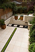 VIEW ACROSS CONTEMPORARY CLASSIC GARDEN WITH PLANTED  RILL  COPPER WATER FEATURE  PORTUGUESE LIMESTONE PAVING AND STEPS .  DESIGNER: CHARLOTTE ROWE