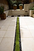PLANTED RILL EDGED WITH BLACK POLISHED PEBBLES RUNS THROUGH CONTEMPORARY CLASSIC GARDEN DESIGNED BY CHARLOTTE ROWE