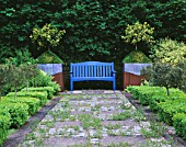 RIDLERS GARDEN  SWANSEA  WALES: VIEW ALONG PATH PAST BOX SQUARES TO BLUE BENCH WITH LEAD AND RUSTY METAL CONTAINERS BESIDE PLANTED WITH HOLLY AND BOX