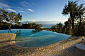 VIEW OF THE ALBANIAN MOUNTAINS WITH  OLIVE TREES AND INFINITY SWIMMING POOL IN THE FOREGROUND: GINA PRICES GARDEN  CORFU