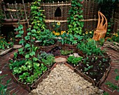 HAMPTON COURT FLOWER SHOW 2005: A TASTE OF SUSSEX. DESIGNER  SUE HITCHINGS. CIRCULAR POTAGER / VEGETABLE GARDEN WITH WILLOW FENCING