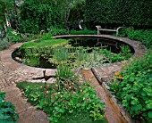 WINGWELL NURSERY  RUTLAND: RILL SPILLS INTO CIRCULAR POOL (POND) WITH STONE SEAT AND WATER SCULPTURE NEW MOON BY GEORGE CUTTS