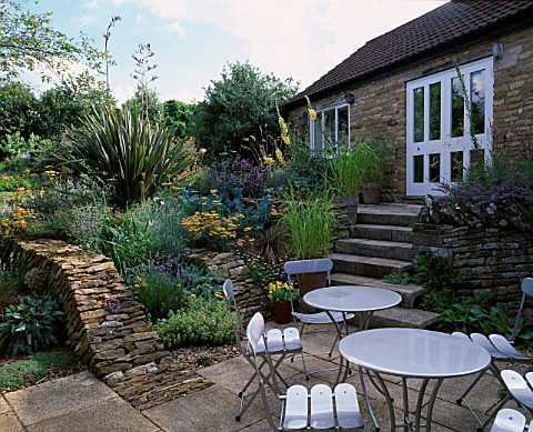 WINGWELL_NURSERY__RUTLAND_PATIO_AT_THE_BACK_OF_THE_HOUSE_WITH_METAL_CHAIRS_AND_TABLES_STONE_WALLLS_P
