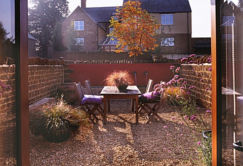 AUTUMNAL_VIEW_FROM_OFFICE_ACROSS_CONTEMPORARY_COURTYARD__WITH_TABLE_AND_CHAIRS__CONTAINERS_WITH_CARE