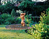 HALL FARM  LINCOLNSHIRE: CARVED WOODEN FEMALE TORSO BY NIGEL SARDESON OVERLOOKING THE POND