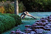 GARDEN DESIGNED BY DUNCAN HEATHER: SCULPTURE BY HELEN SINCLAIR ON THE FROSTY LAWN BESIDE A HEBE AND SEDUM AUTUMN JOY