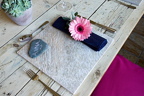 DESIGN_BY_CLARE_MATTHEWS_OUTDOOR_TABLE_SETTING_WITH_STONE_TABLE_MAT__GERBERA_DECORATED_NAPKIN_AND_ST