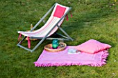 DESIGN BY CLARE MATTHEWS: DECKCHAIR ON LAWN WITH BLANKET  BOOK AND DRINKS