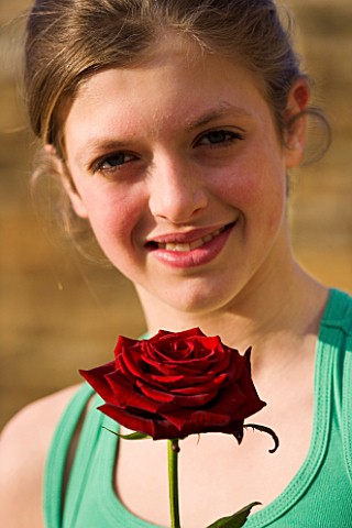 GIRL_AGED_13_HOLDING_A_RED_ROSE_AND_SMILING