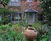 LISETTE PLEASANCE GARDEN  LONDON: FRONT GARDEN WITH GREY PORCH AND LARGE TERRACOTTA CONTAINER