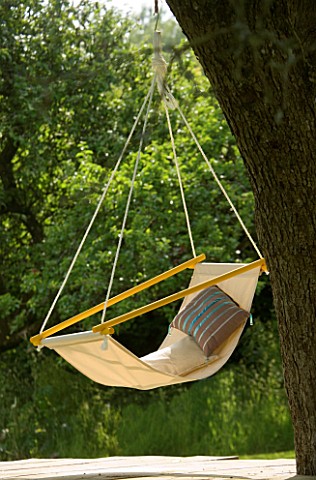 DESIGNER_CLARE_MATTHEWS_HANGING_SEAT_MADE_FROM_DOWEL_AND_CANVAS_HANGS_OFF_A_TREE
