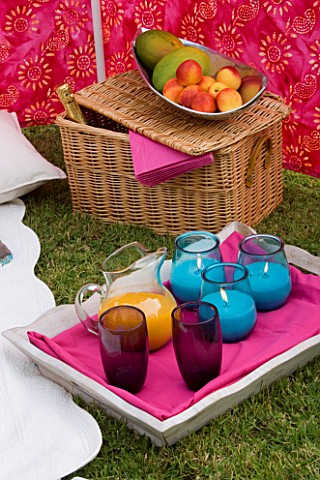 DESIGNER_CLARE_MATTHEWS_WIND_BREAK_SCREEN_PROJECT_TRAY_WITH_GLASSES__ORANGE_JUICE_AND_BLUE_CANDLES__
