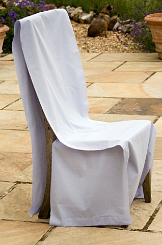 DESIGNER_CLARE_MATTHEWS_WOODEN_CHAIR_WITH_PALE_BLUE_SHEETS_DRAPED_OVER