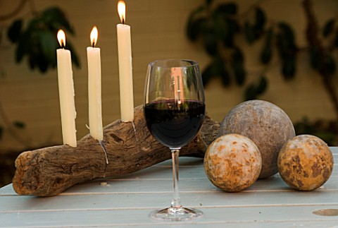 DESIGNER_CLARE_MATTHEWS__DRIFTWOOD_CANDLE_PROJECT__CANDLE_HOLDER_AT_NIGHT_WITH_GLASS_OF_WINE_AND_STO