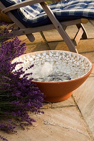 DESIGNER_CLARE_MATTHEWS__BUBBLING_BOWL_PROJECT_TERRACOTTA_WATER_FEATURE_ON_PATIO_BESIDE_LAVENDER_AND