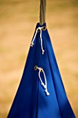 DESIGNER: CLARE MATTHEWS - SWINGING COCOON PROJECT: CLOSE UP OF THE STRINGS TYING CANVAS TOGETHER ON THE BLUE COCOON HANGING FROM TREE