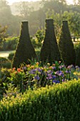PETTIFERS  OXFORDSHIRE: THE PARTERRE WITH CLIPPED BOX  YEW AND AGAPANTHUS HEADBOURNE HYBRIDS