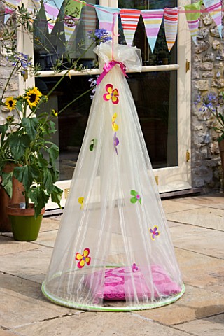 DESIGNER_CLARE_MATTHEWS_CHILDRENS_PARTY__HANGING_COCOON_ON_PATIO_WITH_CUSHION