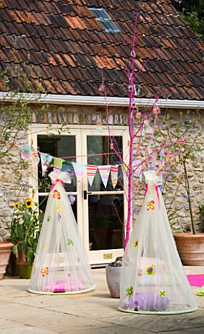 DESIGNER_CLARE_MATTHEWS_CHILDRENS_PARTY__HANGING_COCOONS_ON_PATIO_WITH_CUSHION_AND_BUNTING