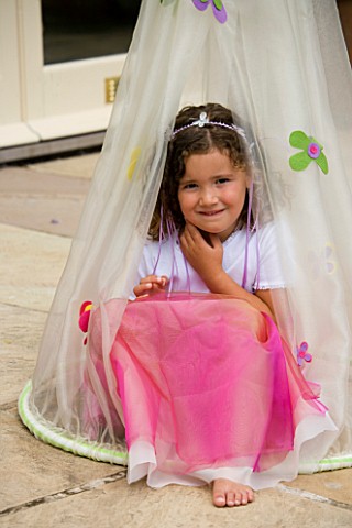 DESIGNER_CLARE_MATTHEWS_CHILDRENS_PARTY__GIRL_SITTING_IN_COCOON_ON_PATIO