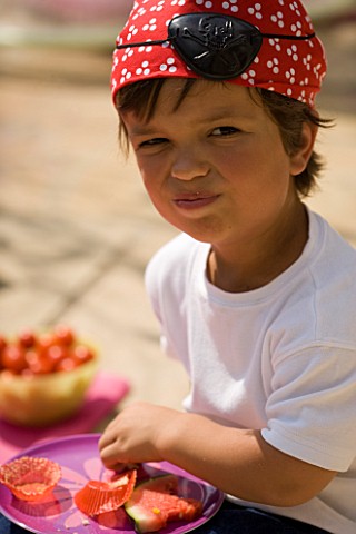 DESIGNER_CLARE_MATTHEWS_CHILDRENS_PARTY__BOY_DRESSED_AS_PIRATE_EATING_PICNIC