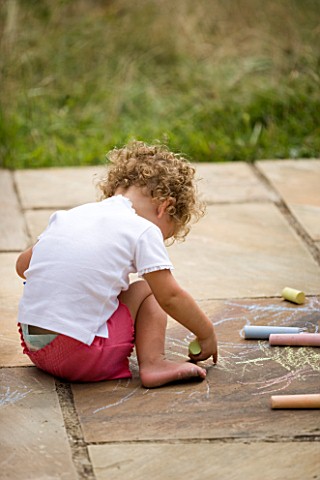 DESIGNER_CLARE_MATTHEWS_CHALK_GAME__GIRL_DRAWING_WITH_CHALK_ON_PATIO