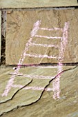 DESIGNER: CLARE MATTHEWS: SNAKES AND LADDERS. CHALK DRAWING OF LADDER ON PATIO