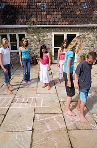 DESIGNER_CLARE_MATTHEWS_SNAKES_AND_LADDERS_CHILDREN_PLAYING_SNAKES_AND_LADDERS_ON_THE_PATIO