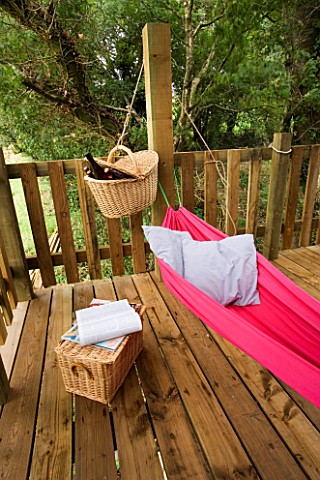 DESIGNER_CLARE_MATTHEWS_TREE_HOUSE_PROJECT__PINK_HAMMOCK_WITH_MAGAZINES_AND_BEER_IN_BASKET