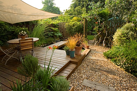 EXOTIC_SHADE_PLANTING_OF_GRASSES__PHORMIUM__BAMBOO__ROSEMARY_AND_OTHER_FOLIAGE_PLANTS_WITH_CANOPY_OV